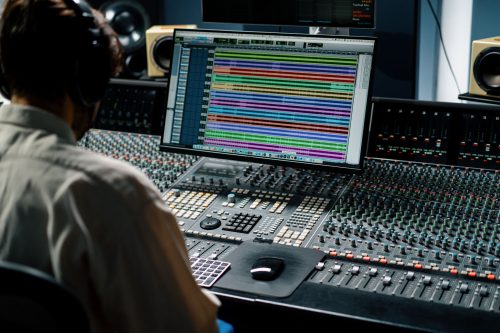 Sound engineer working in music studio with monitors and equaliz